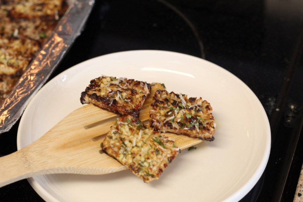 placing cooked keto crispy potato bites on a plate 