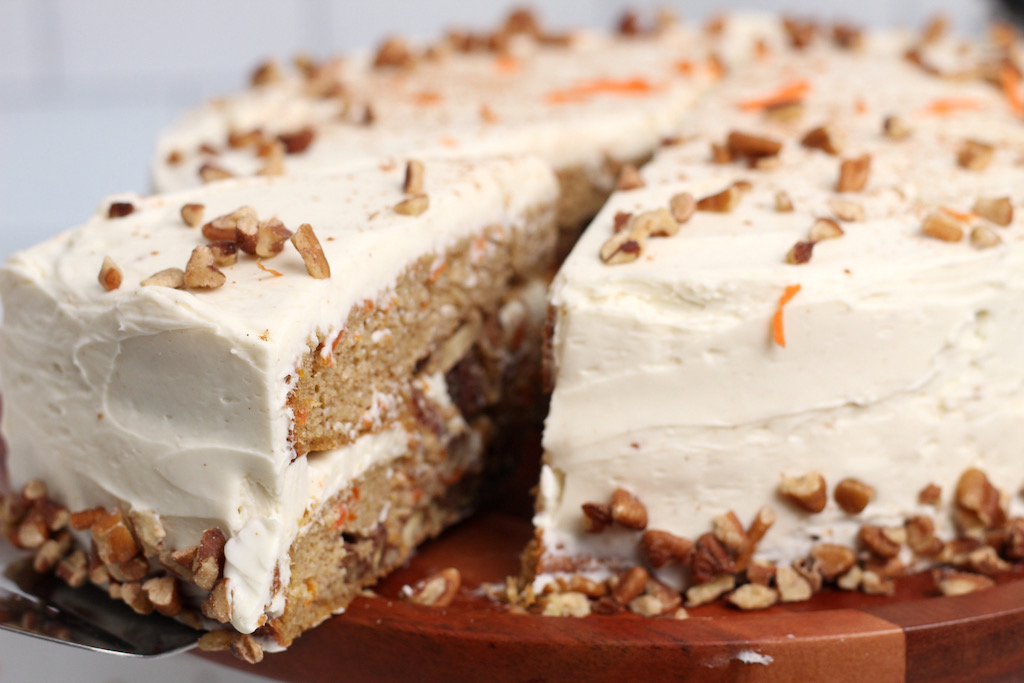 taking slice out of keto carrot cake with cream cheese frosting