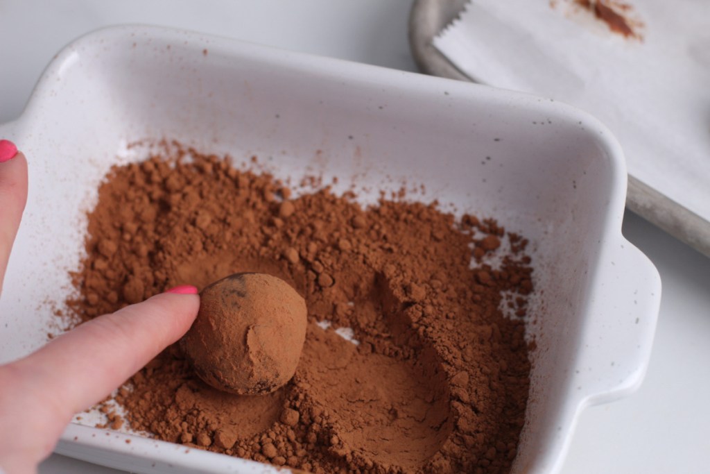 rolling keto chocolate truffle in cocoa powder