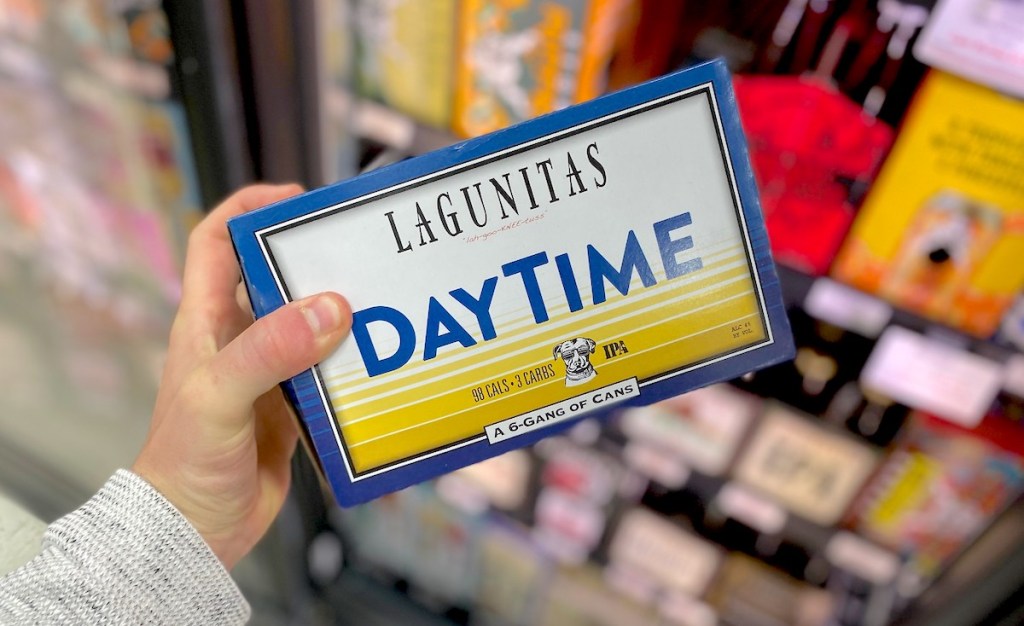 hand holding a pack of lagunitas daytime beer in front of fridge