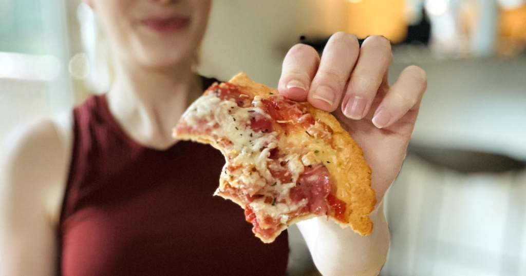 holding out half eaten keto pizza crust