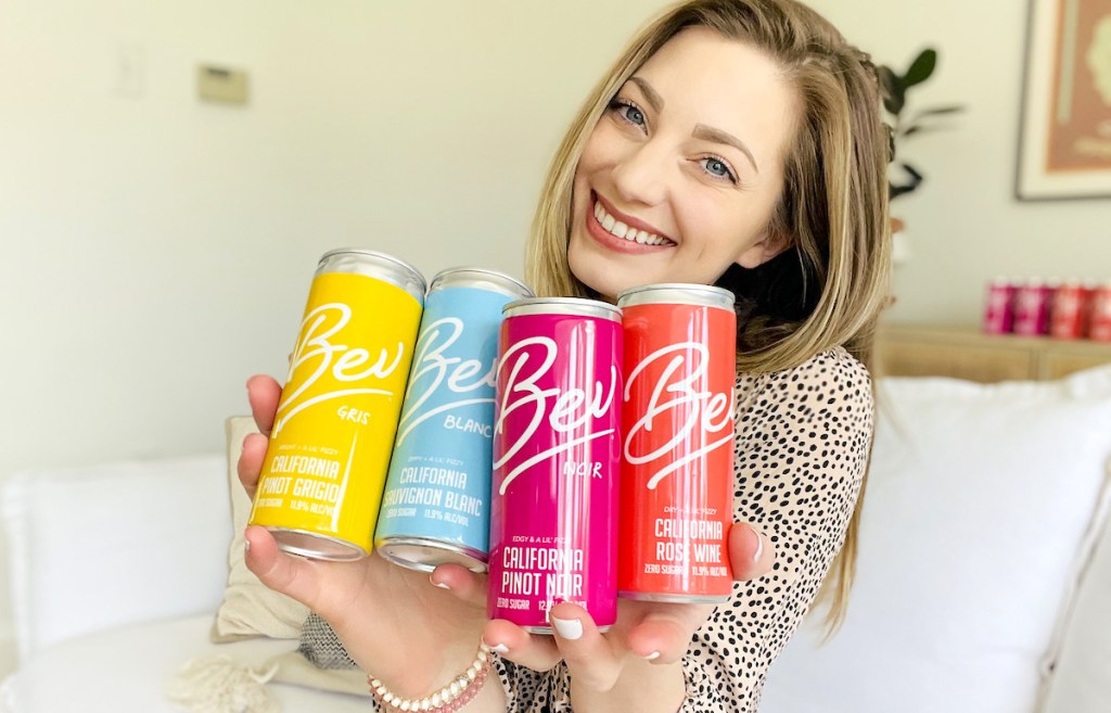 woman holding colorful cans of alcohol
