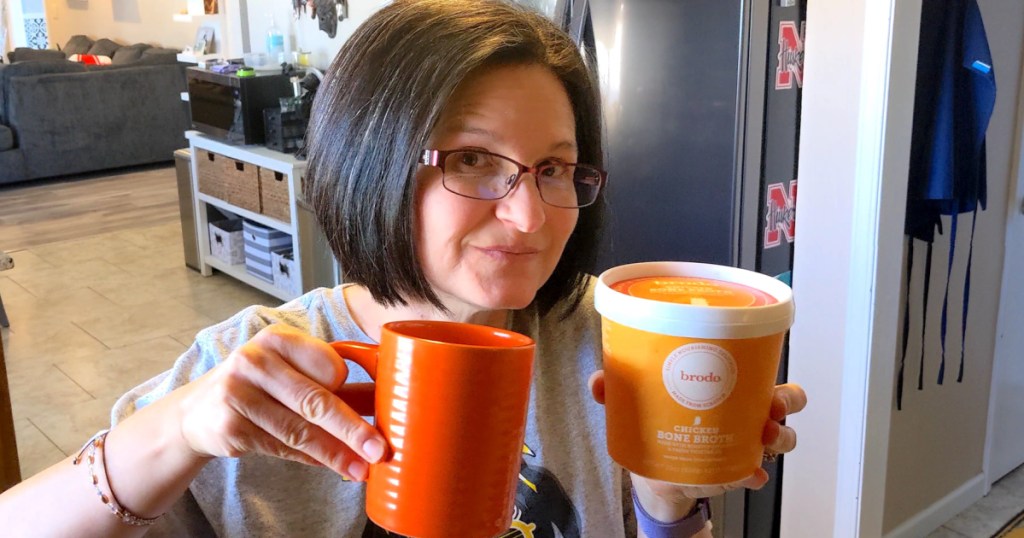 woman holding Brodo chicken bone broth with coffee mug 