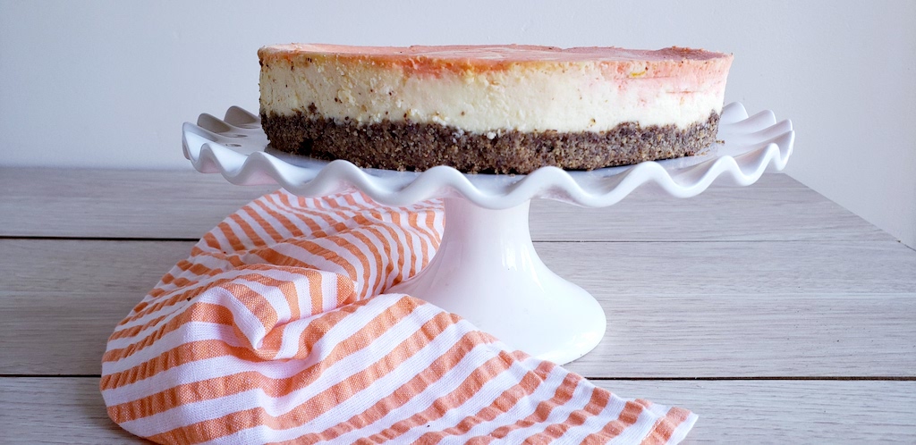 keto orange creamsicle cheesecake on glass cake dish 