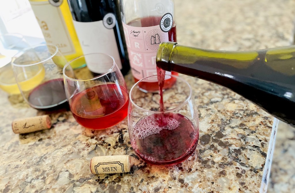 bottle of red wine being poured into glass