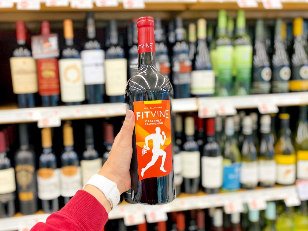 hand holding a bottle of fit vine wine in store aisle