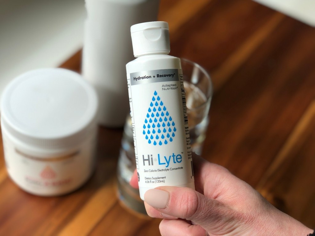 holding a bottle of Hi Lyte electrolyte solution