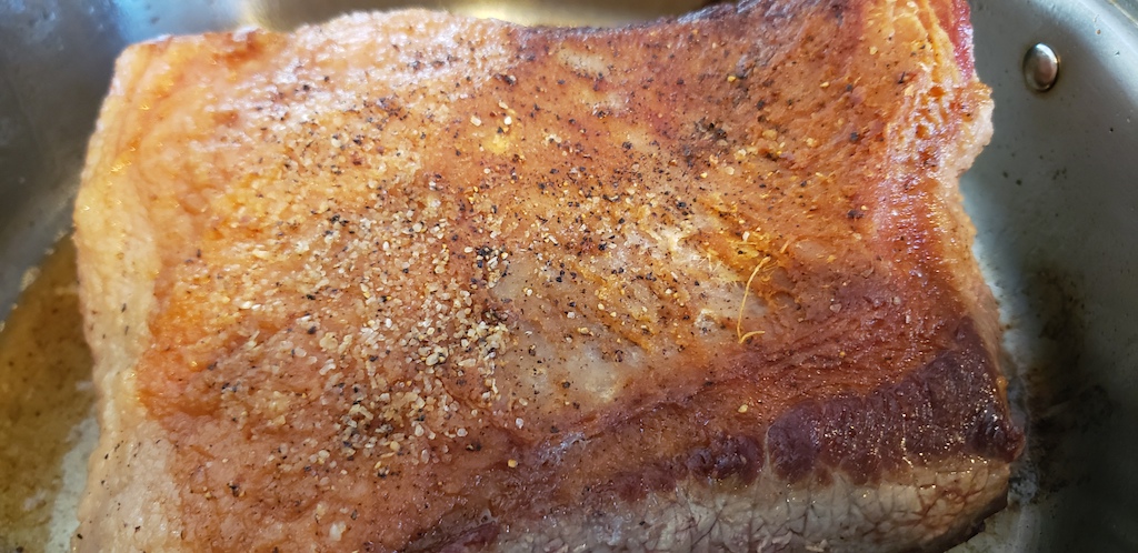 seasoned keto brisket in pan 