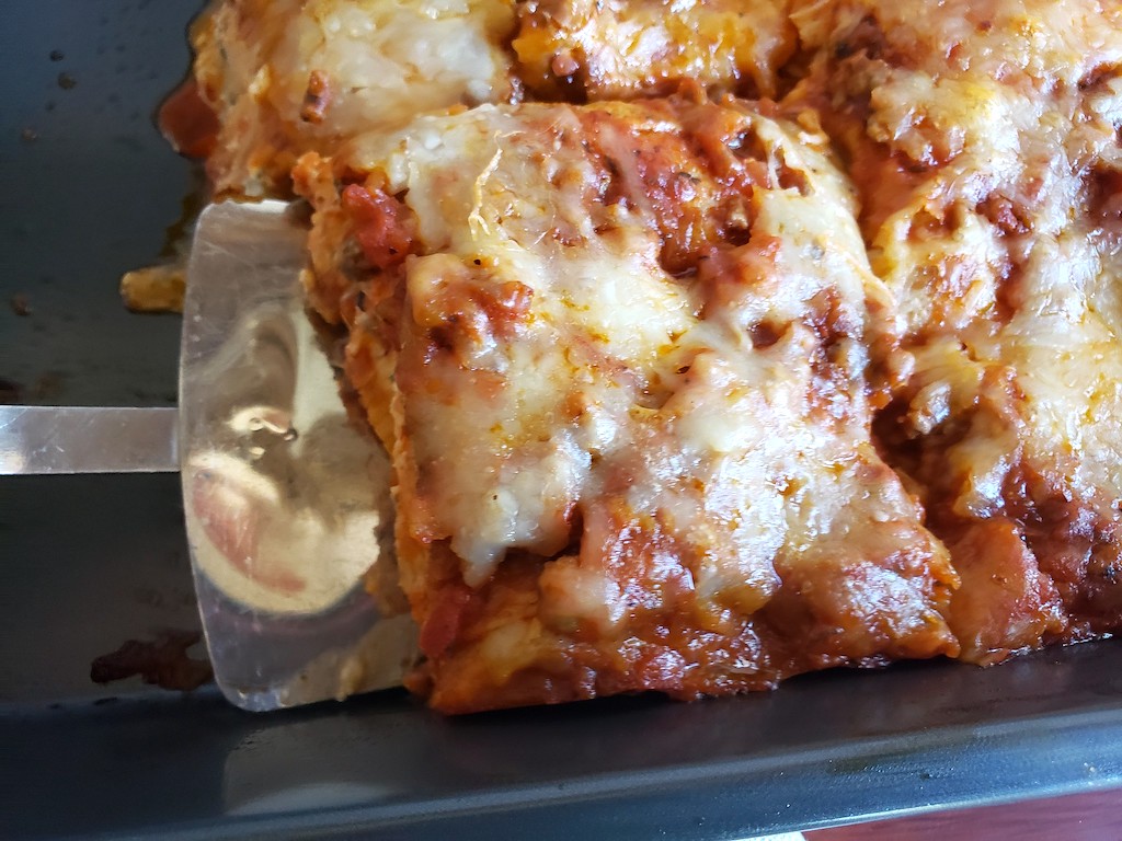 using spatula to pick up low-carb lasagna slice 