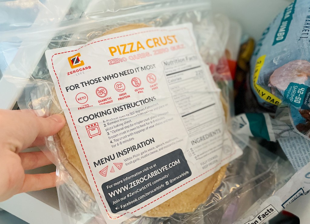 hand pulling out zerocarb lyfe keto pizza crust from freezer