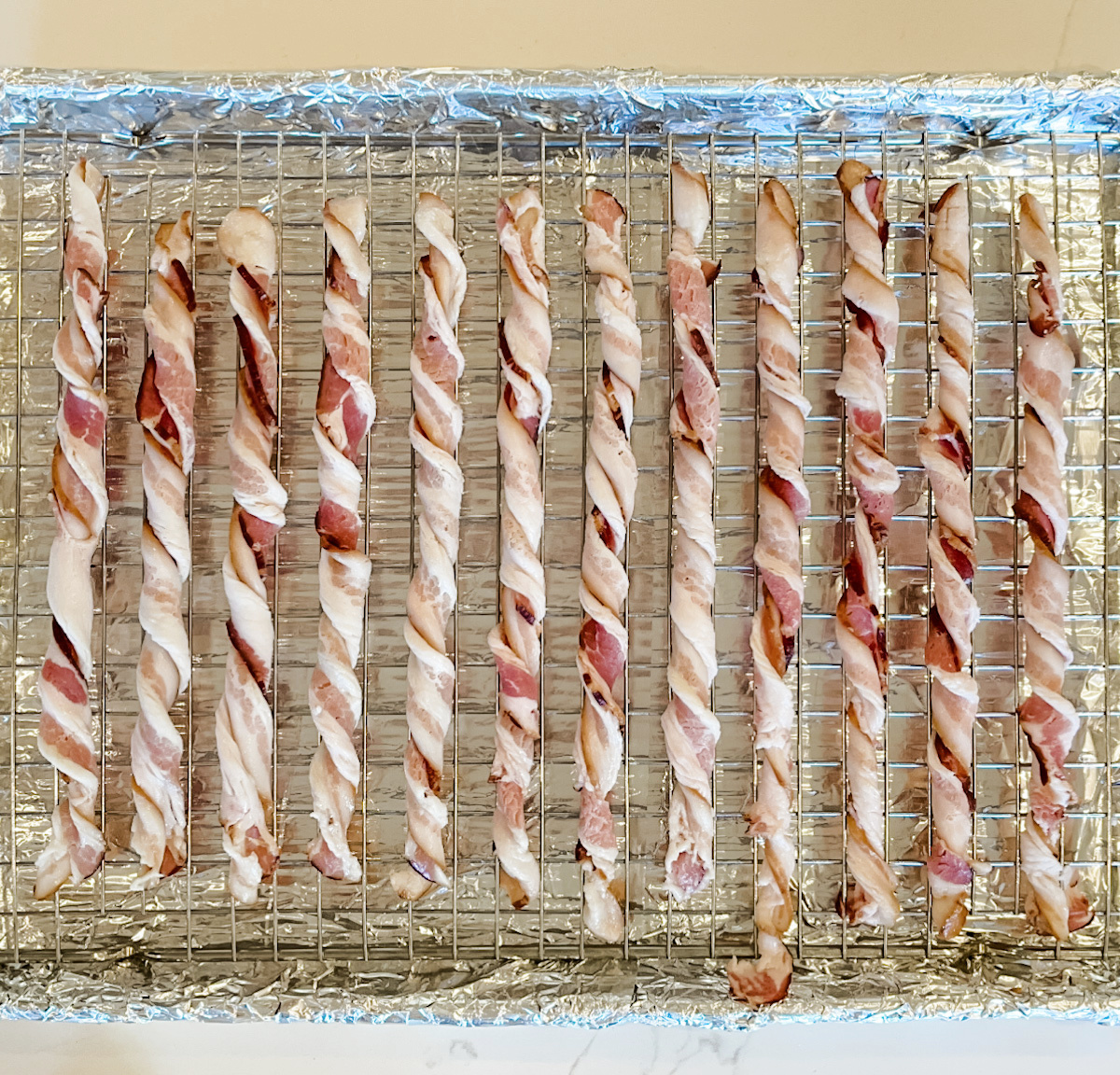 raw bacon twisted on wire rack 