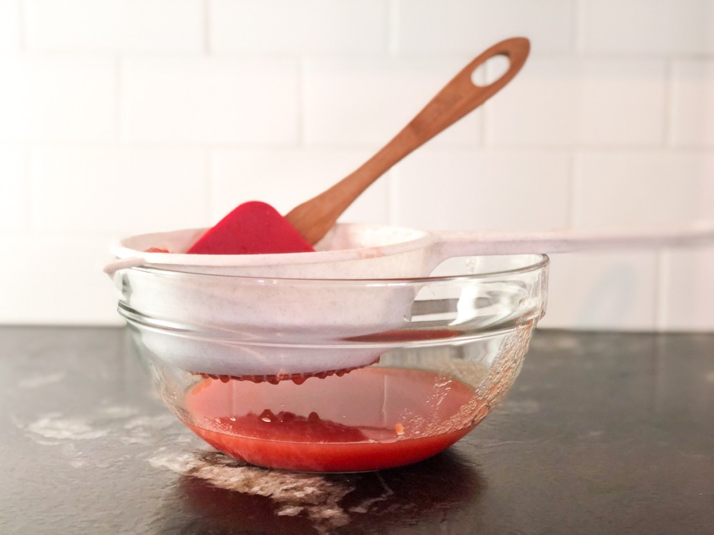 draining liquid from canned whole tomatoes with strainer