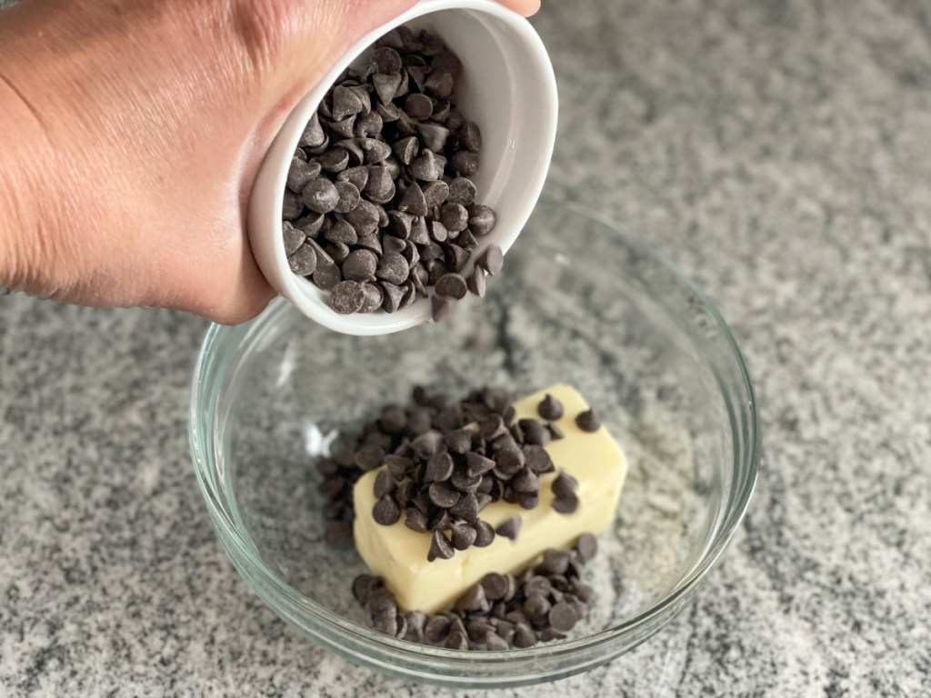 pouring chocolate chips in a bowl with butter