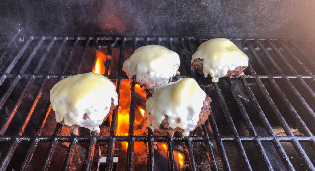 cheese melting on burgers on grill