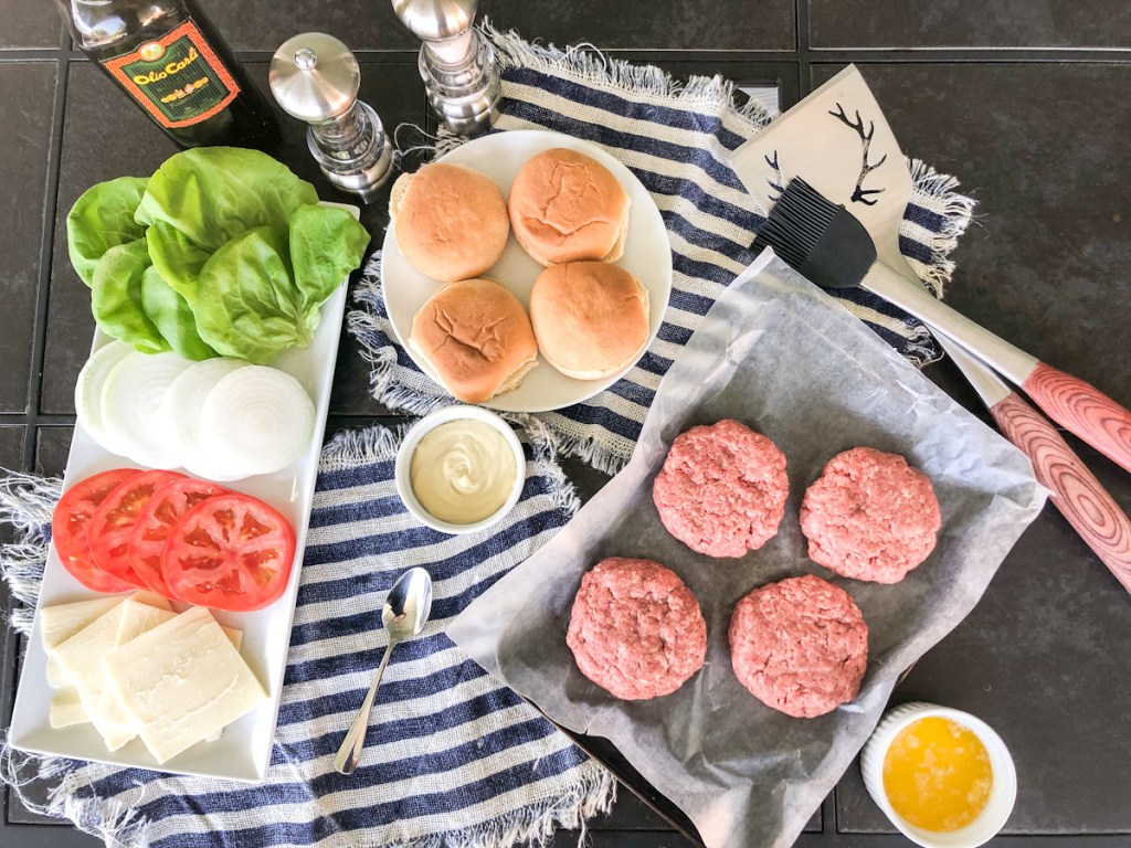 raw burgers ready to grill and toppings