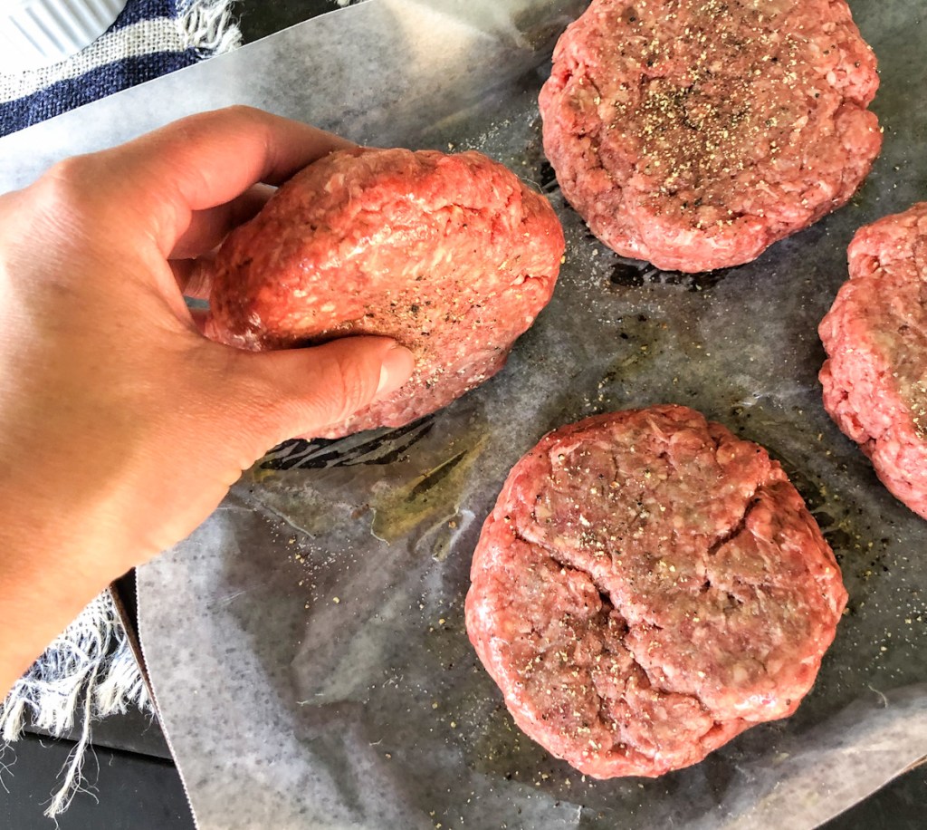 Seasoning the sides of hamburger patty