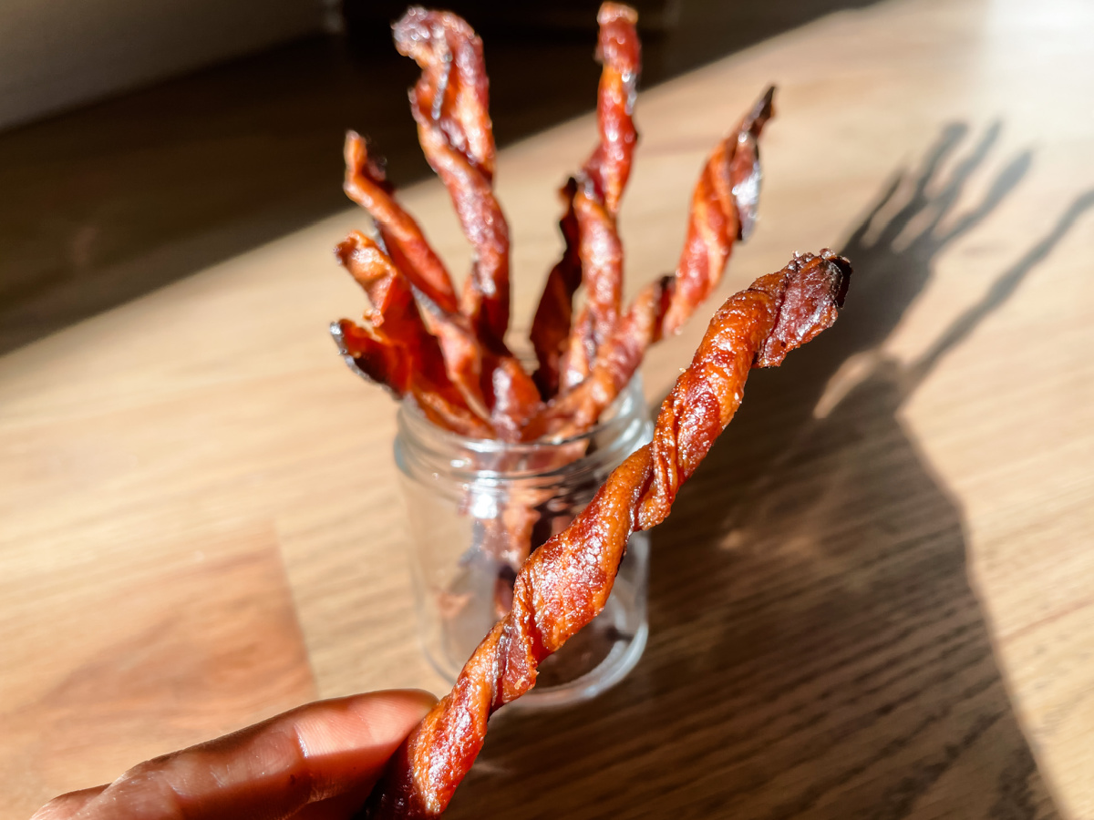 holding twisted Candied Bacon