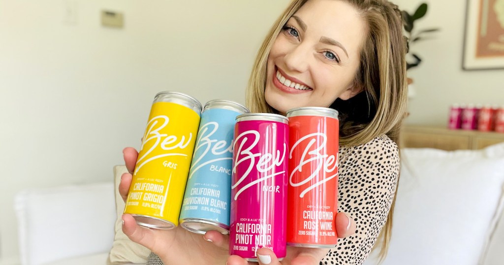 woman holding up rainbow variety of bev canned wines