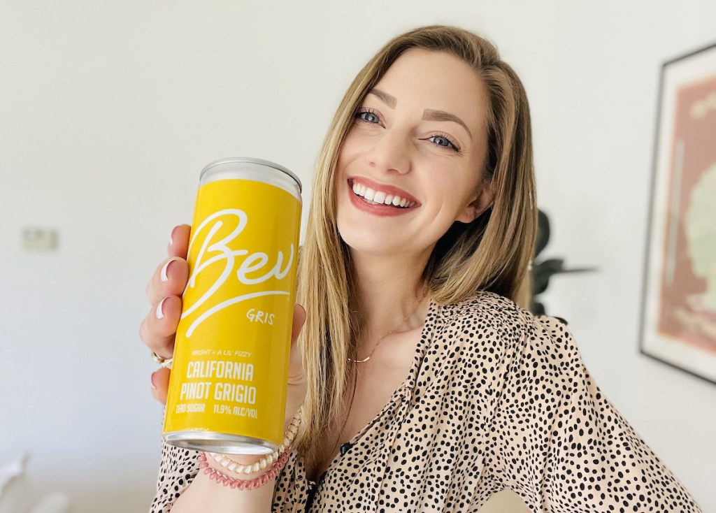 woman holding can of yellow bev wine