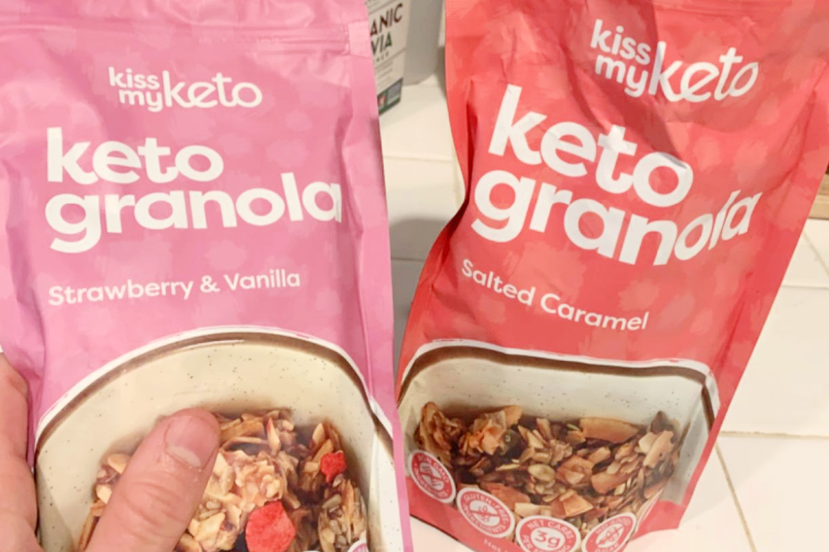 hand holding two bags of granola