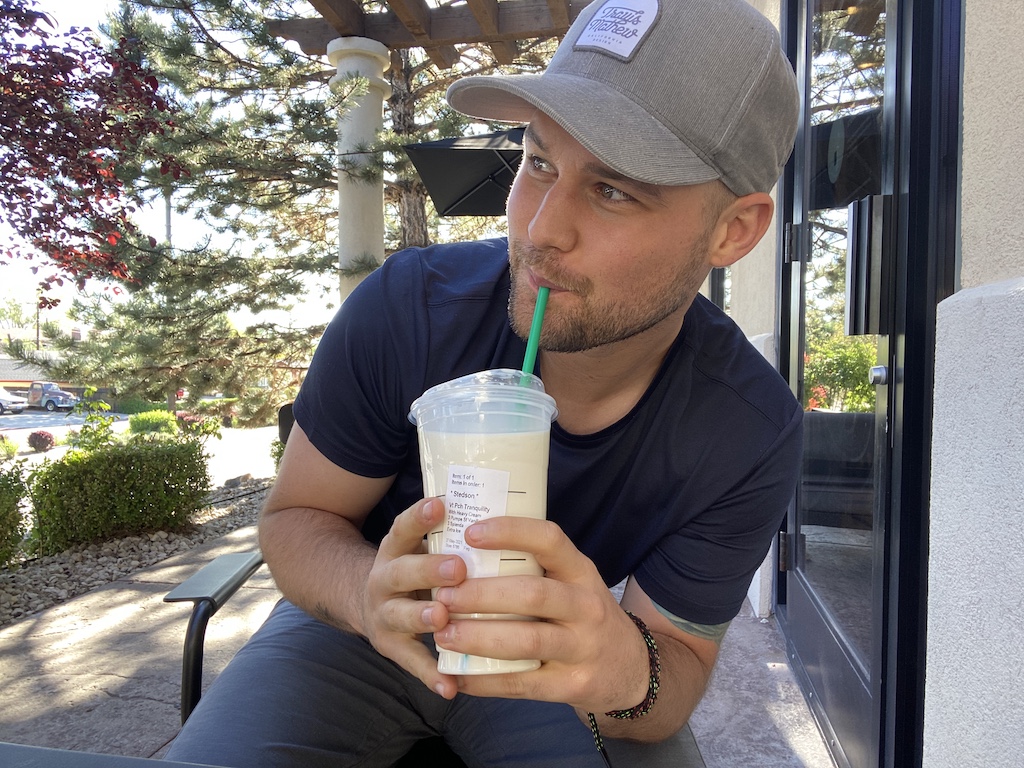 man drinking Starbucks peaches and cream keto drink