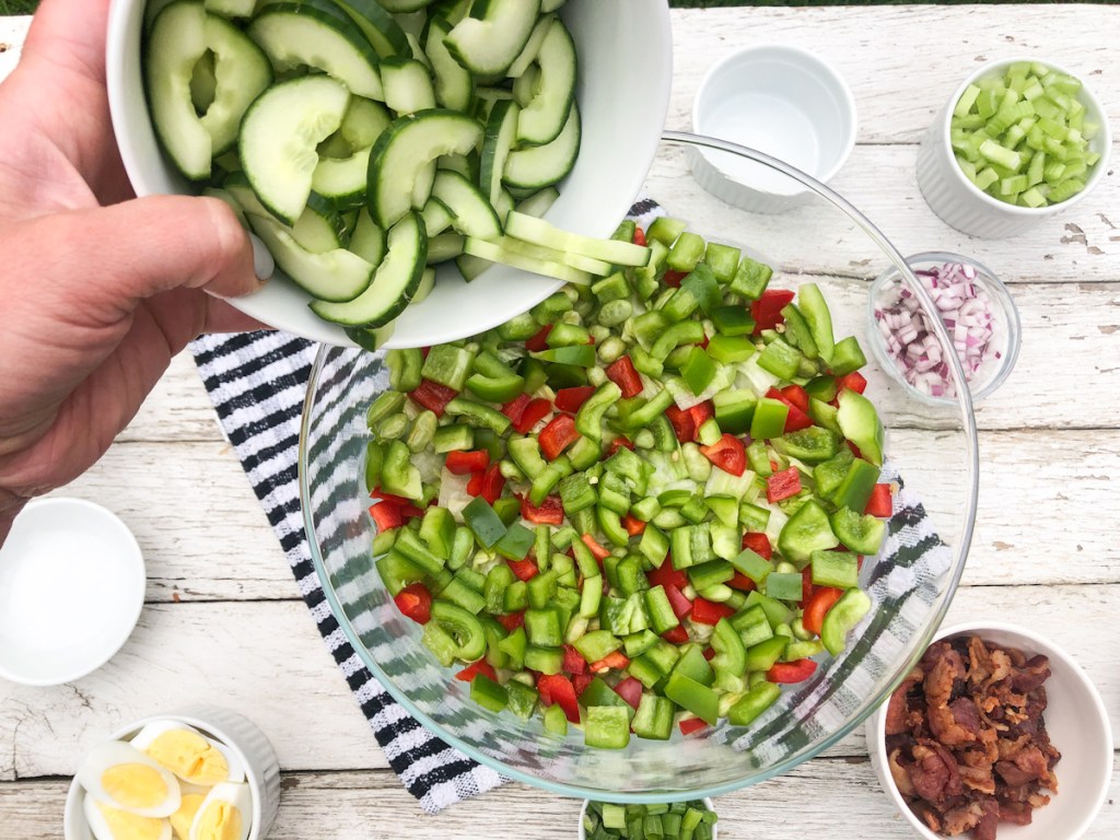 adding cucumbers to a keto salad