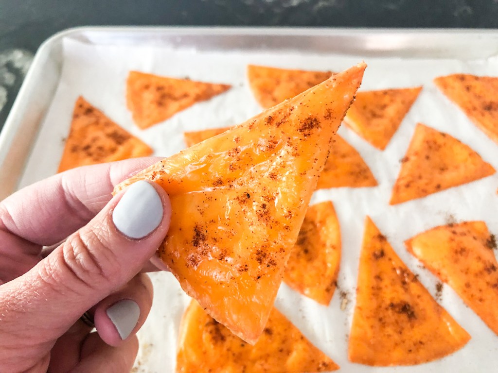 holding a cheese tortilla chip