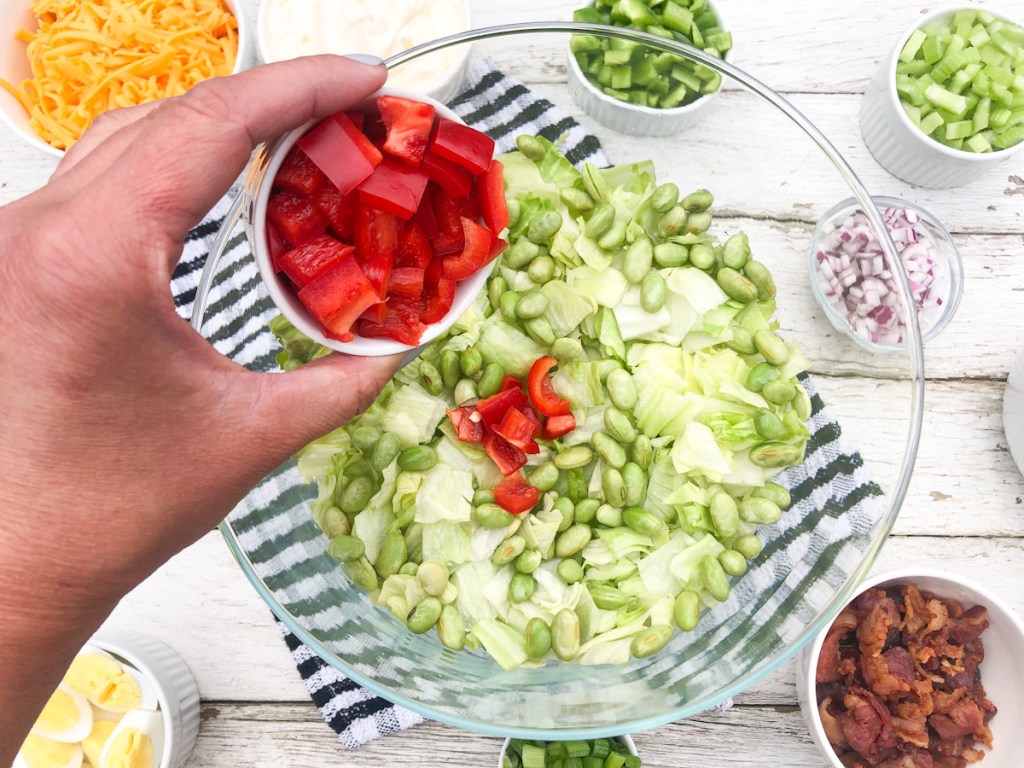 adding red bell peppers to a dish