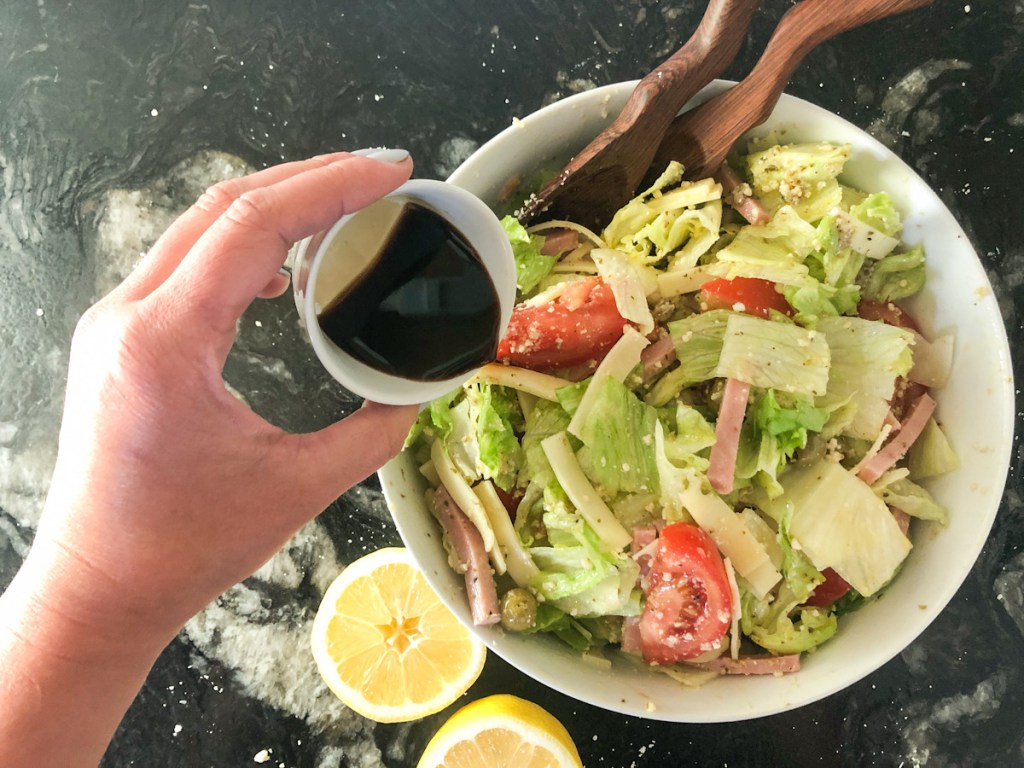 pouring dressing on 1905 salad