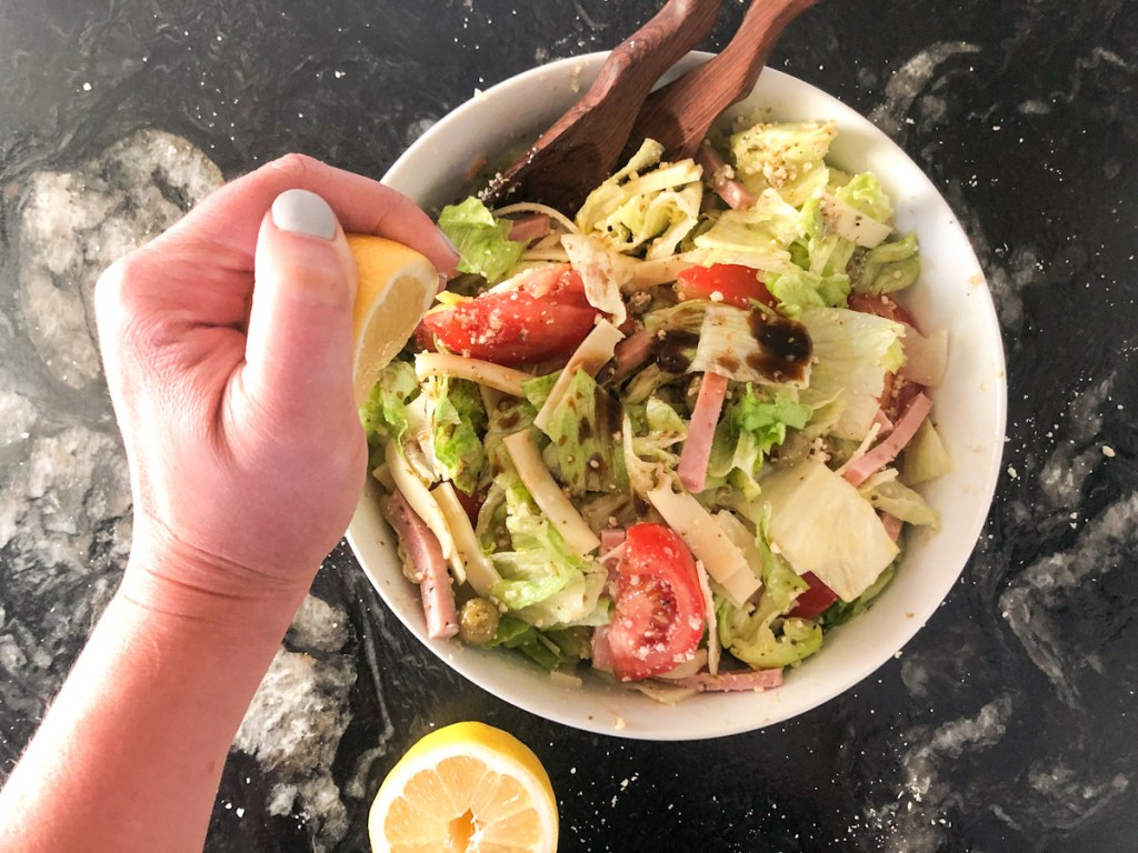 squeezing lemon over keto salad