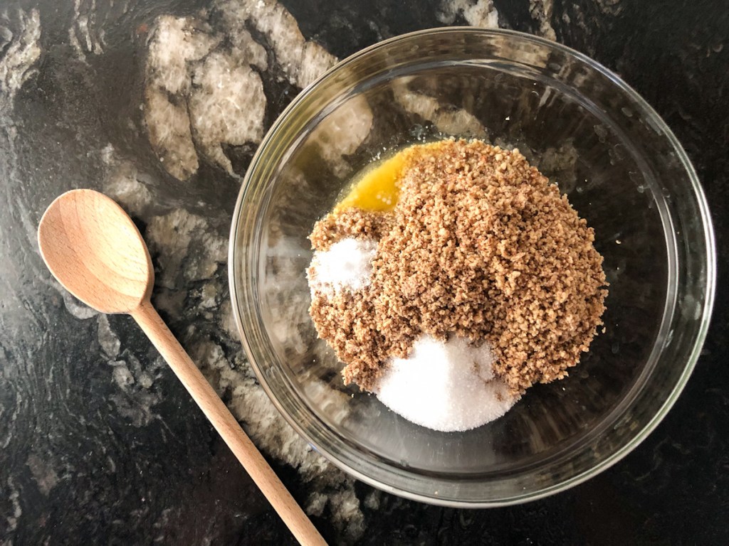 pecans, melted butter, salt, and erythritol in a bowl