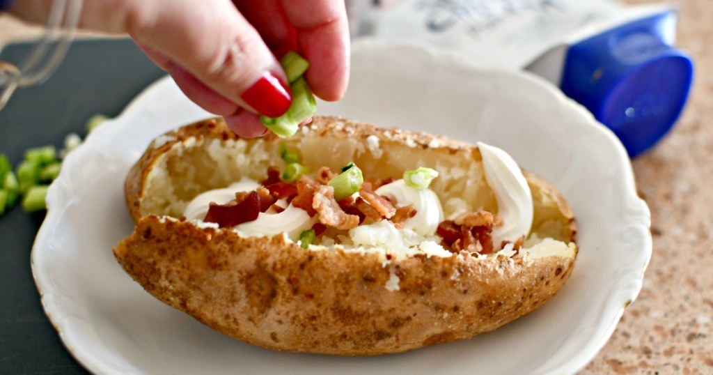 adding toppings to baked potato