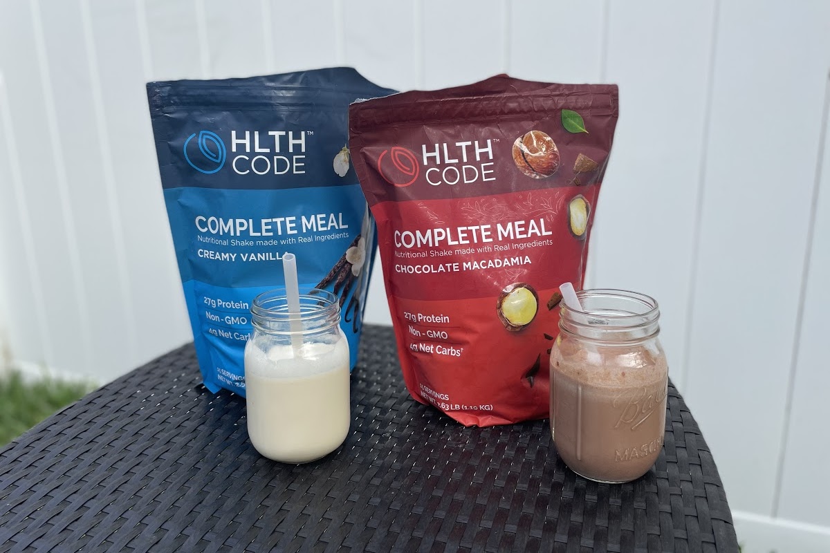 chocolate and vanilla shakes beside meal replacement powder bags on table