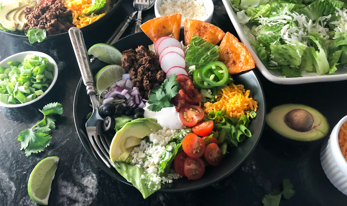 keto taco salad on table surrounded by ingredients