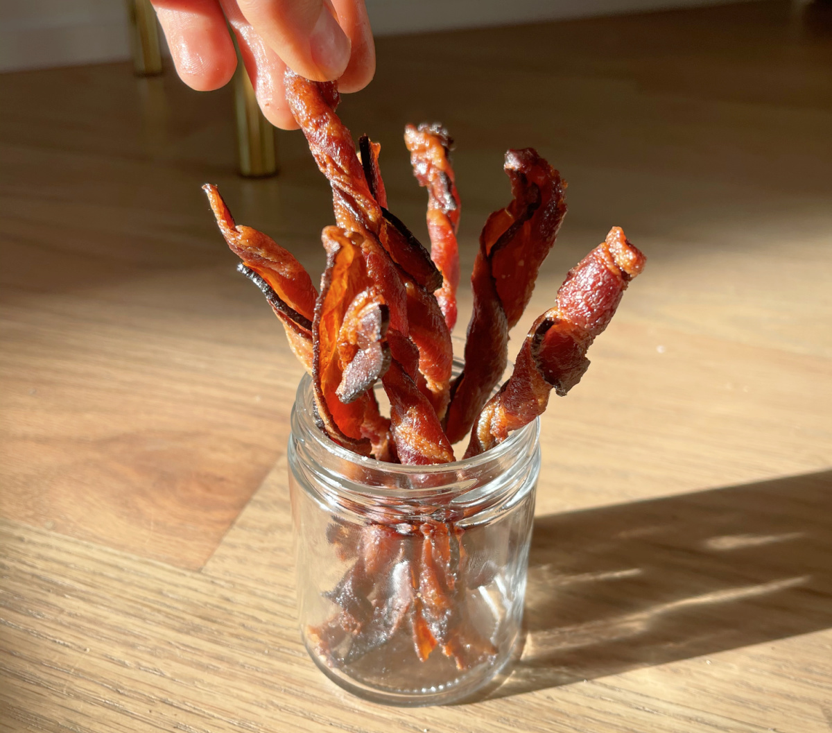 hand grabbing bacon twist out of a jar