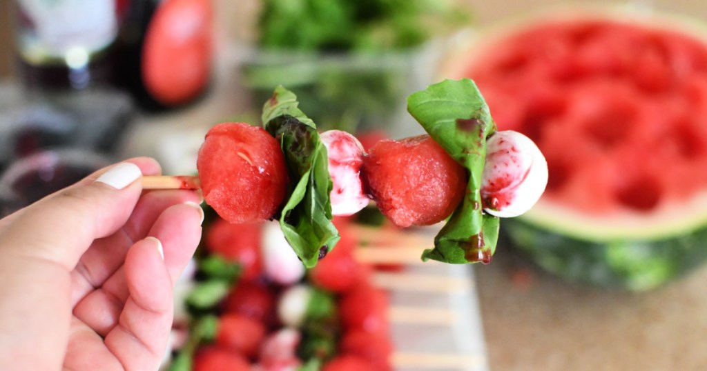 holding watermelon caprese stick