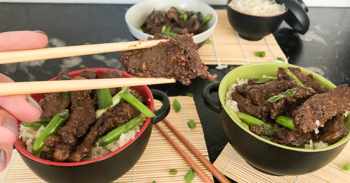 holding a piece of keto crockpot slow cooker Mongolian Beef with chopsticks