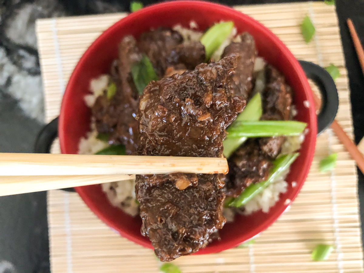 holding keto crockpot Mongolian Beef in chopsticks