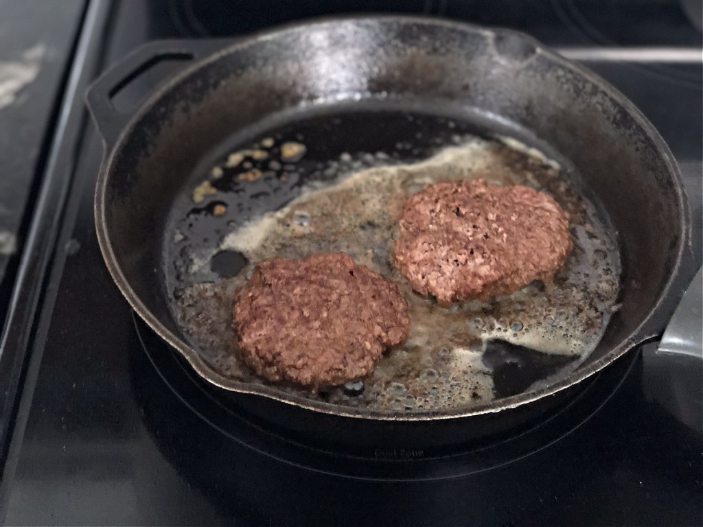 burgers cooking in a skillet