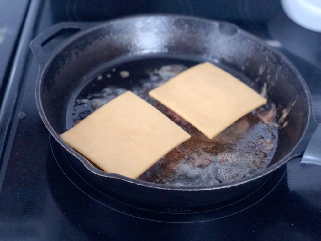 cheese on burgers in a skillet 