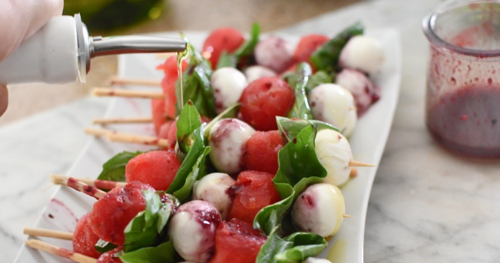 drizzling olive oil on watermelon caprese