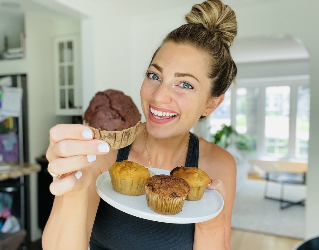 woman holding a plate of keto bakery muffins