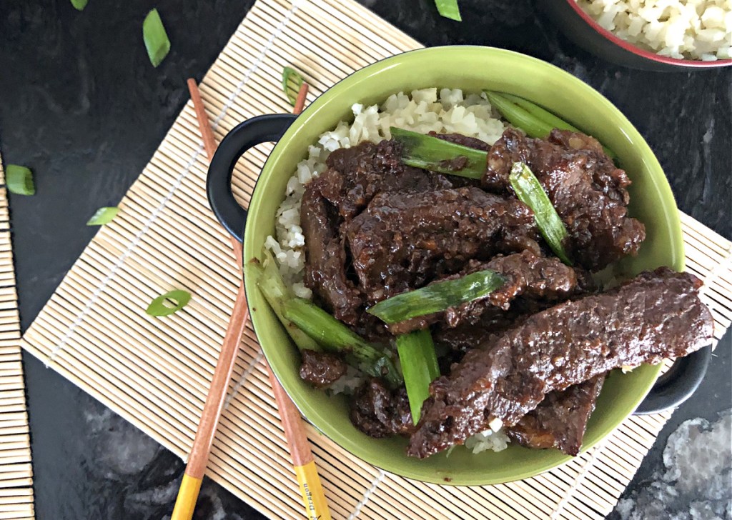 keto crockpot mongolian beef in green bowl with chopsticks