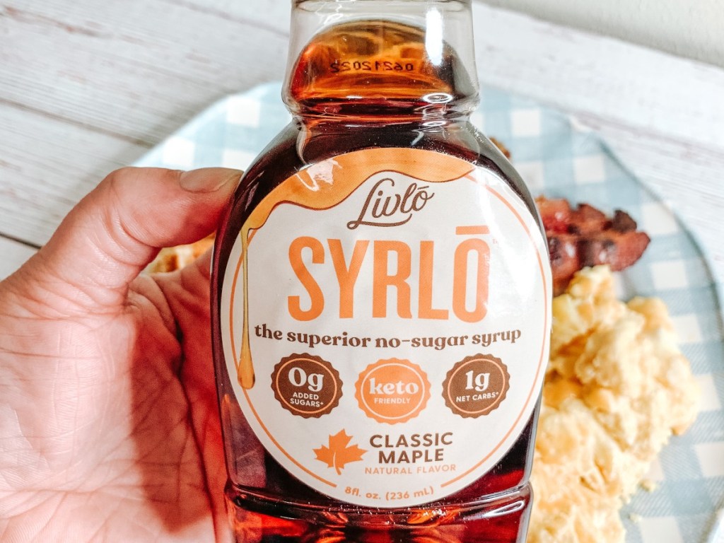 holding a bottle of Livlo maple syrup