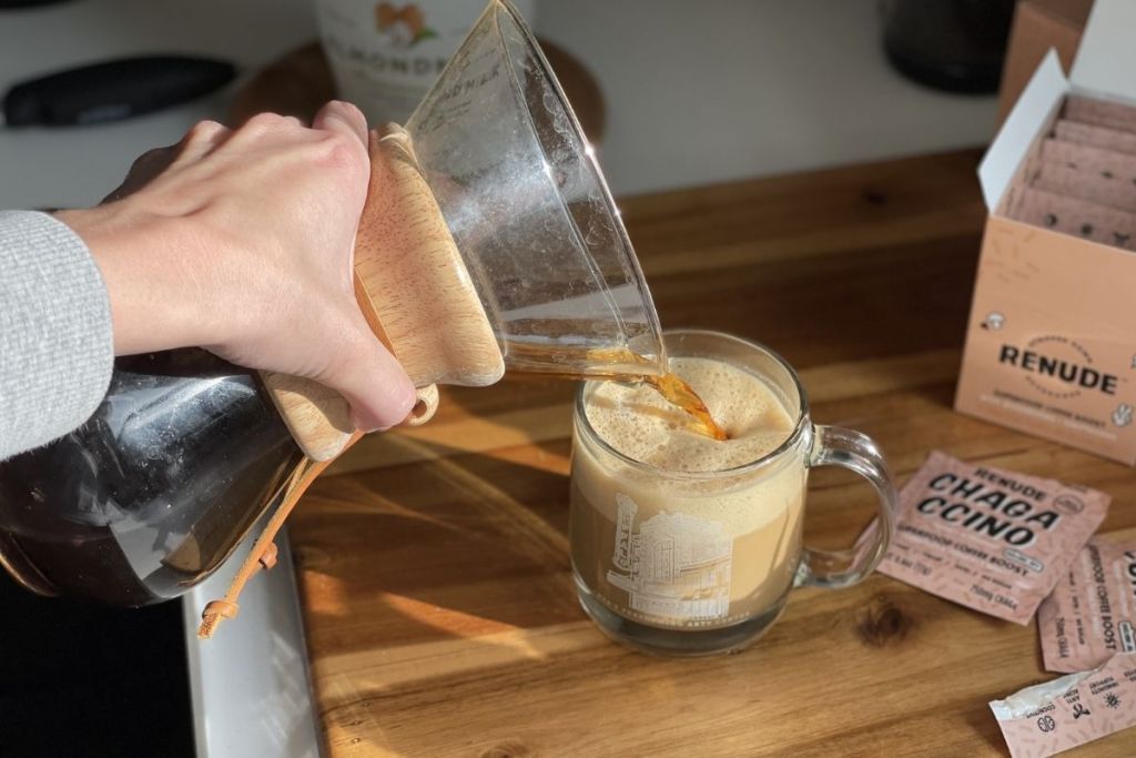 pouring coffee into a chagaccino and milk mixture