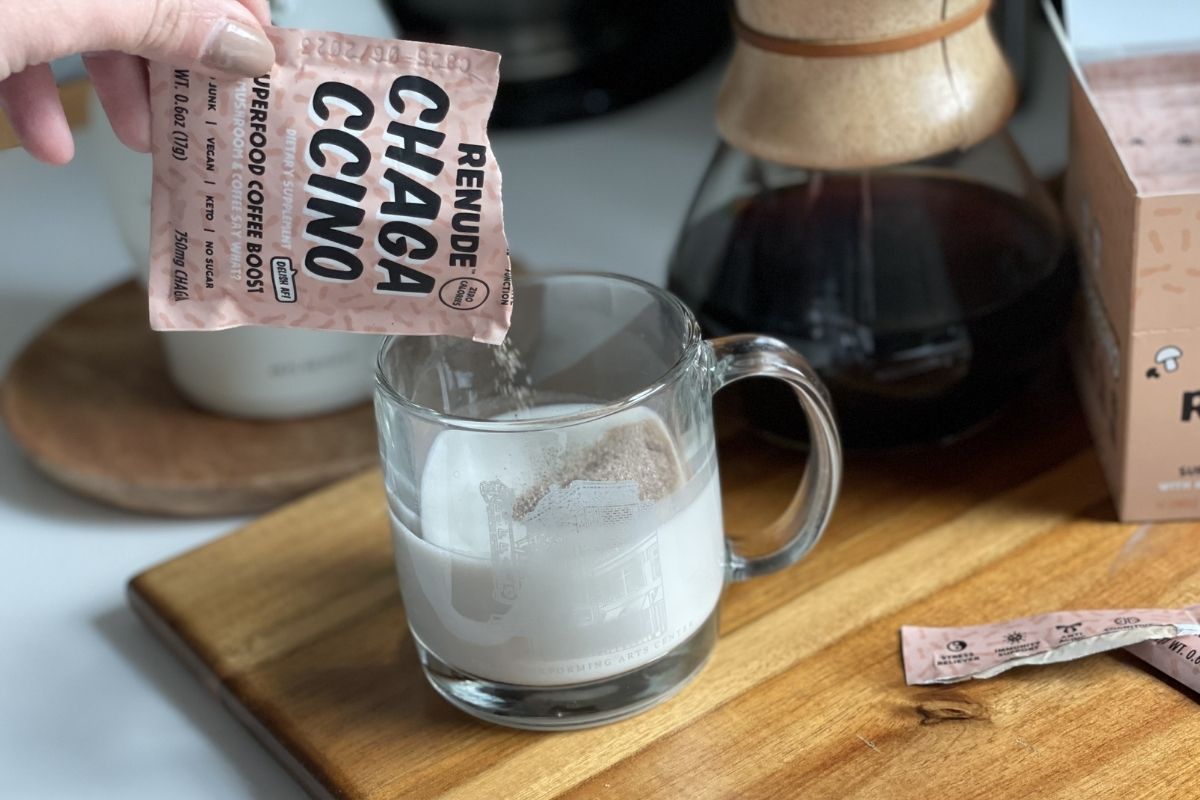 pouring Renude Chagaccino packet into a cup of frothed milk