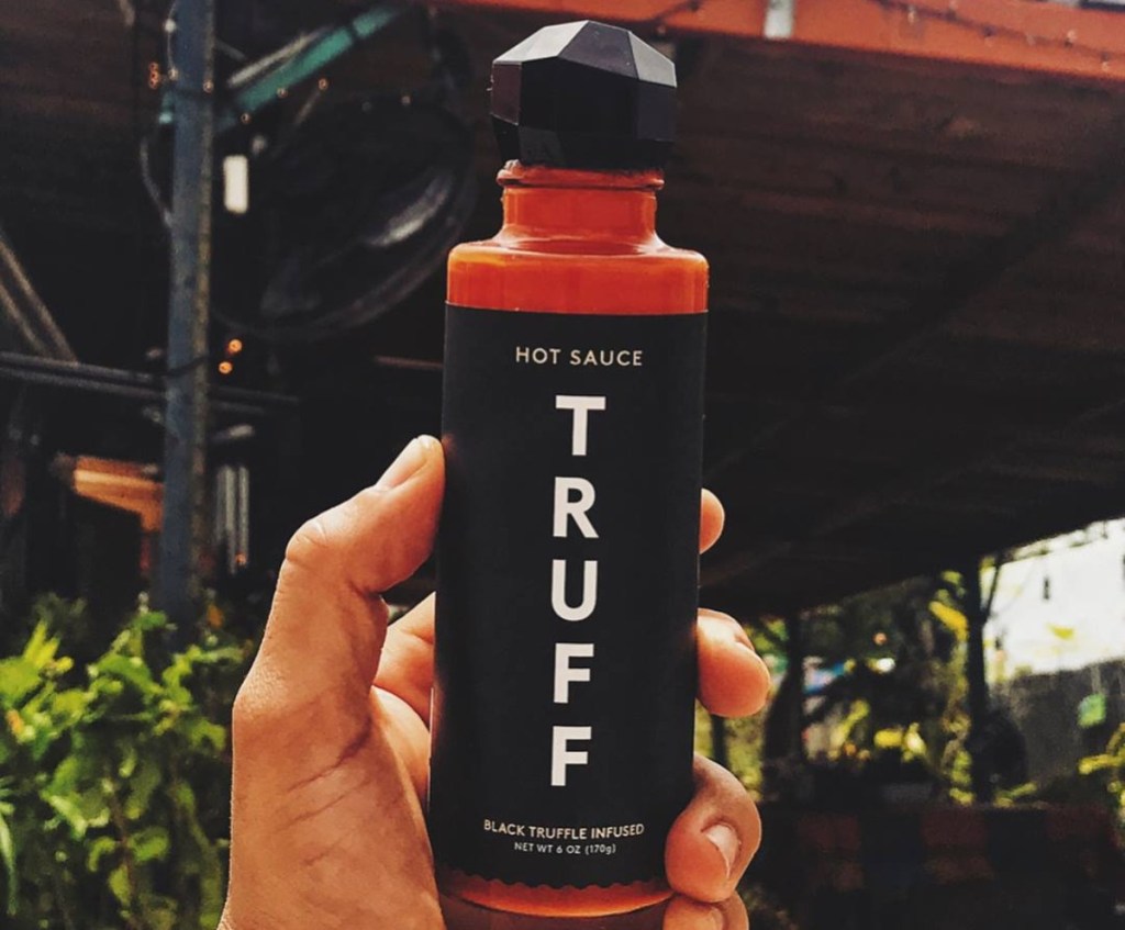 holding a bottle of Truff hot sauce