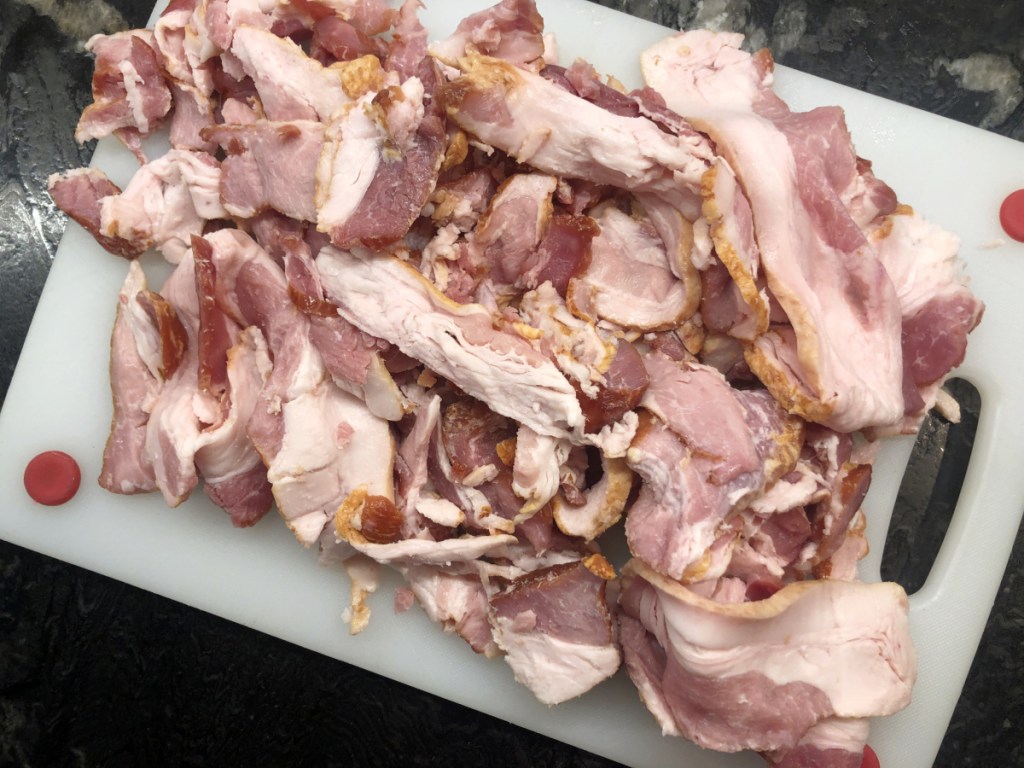 bacon ends and pieces raw on a cutting board