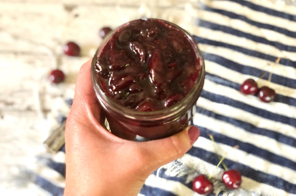 hand holding a jar of fruit