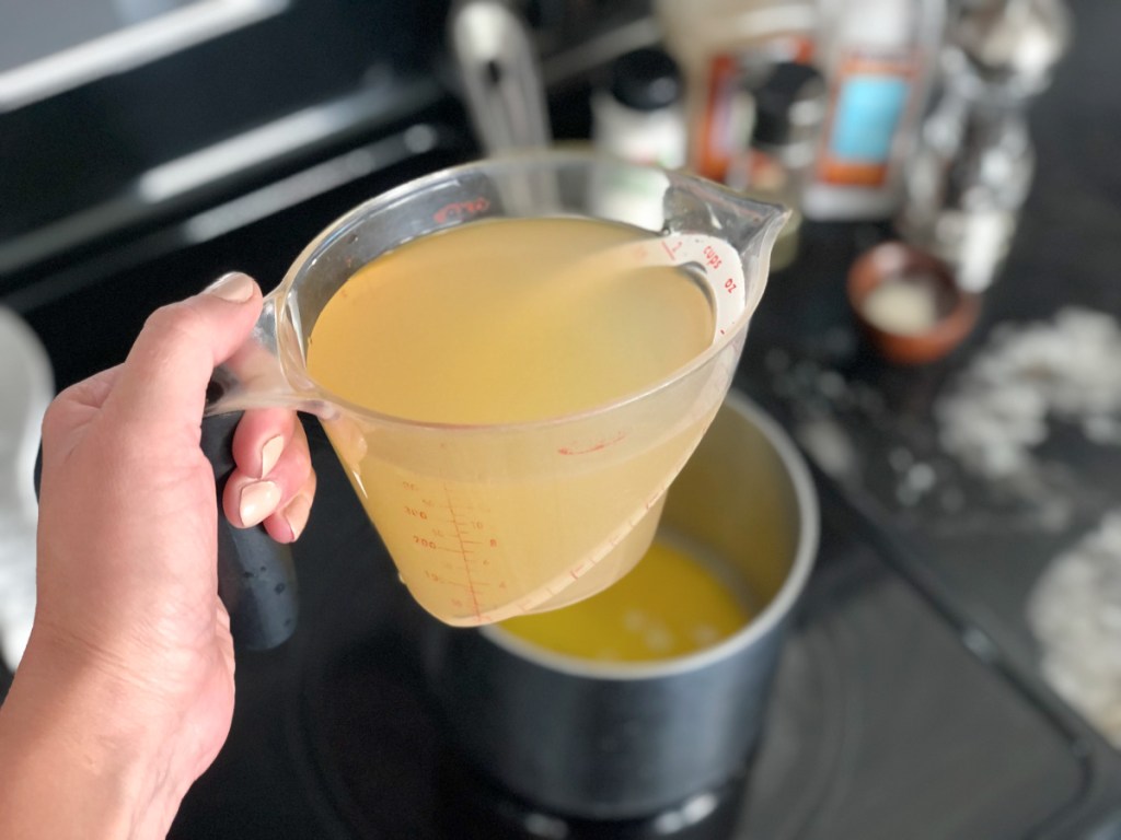 pouring broth into a saucepan